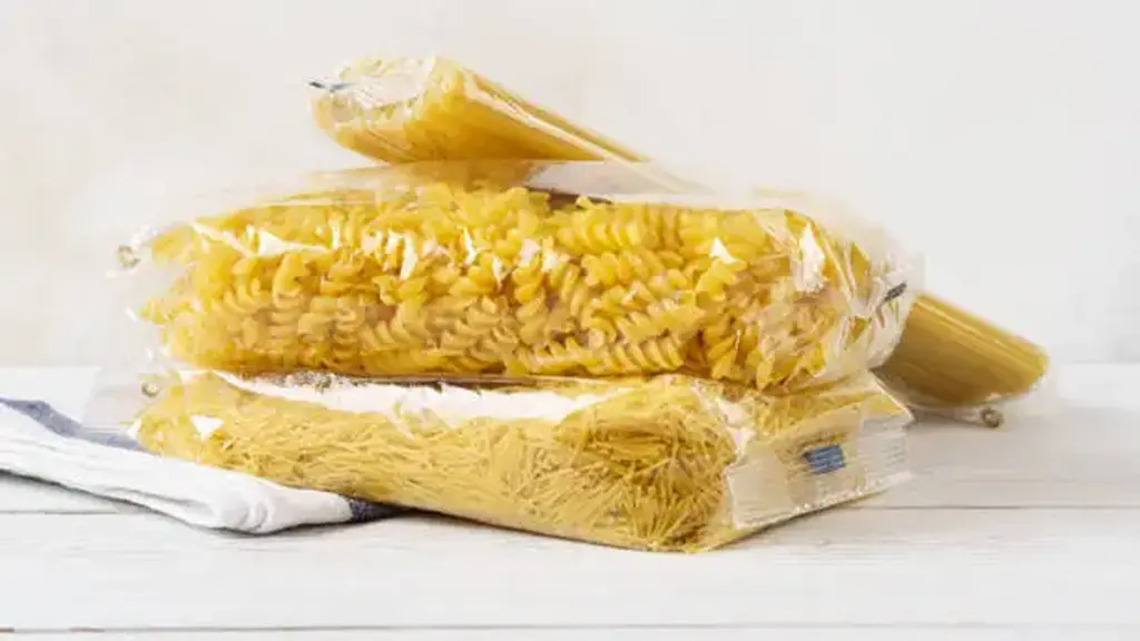 Various pasta in transparent plastic bags on a kitchen table