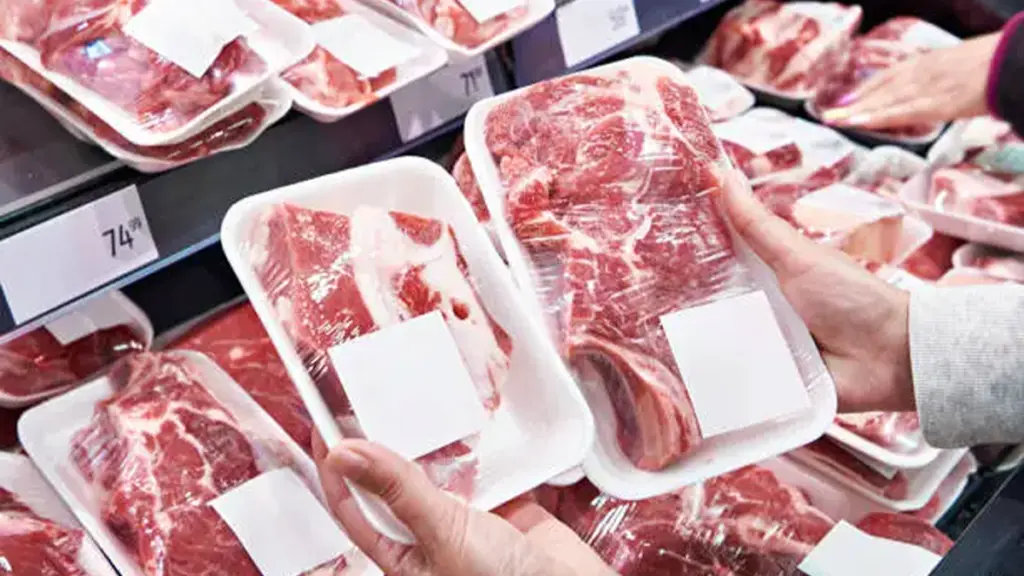 Hand with beef meat in shop