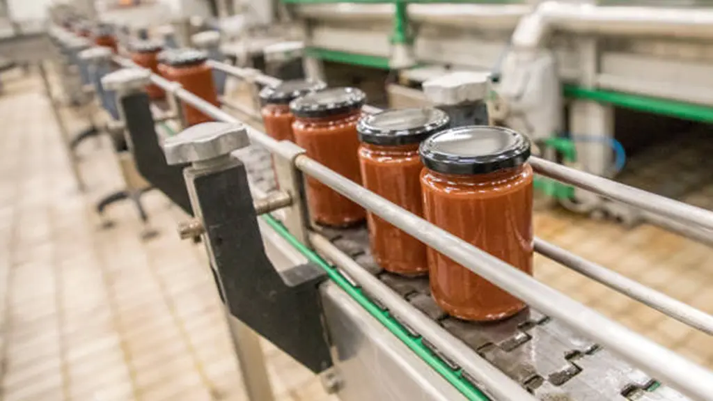 Glass jars with different kinds of jam on packaging line