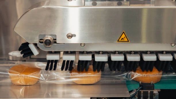 Industrial sealing machine packaging bread on conveyor belt