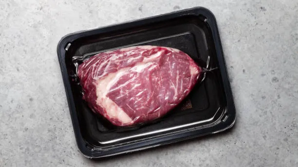 Premium beef ribeye steak in vacuum skin packaging (VSP) on a black tray for food packaging applications